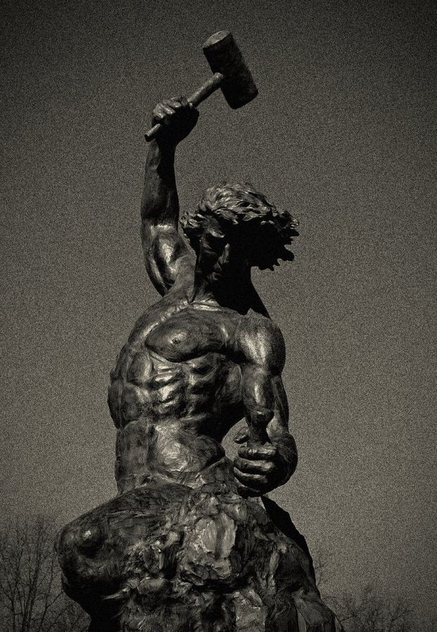 Bronze statue of a man carving his own form from stone